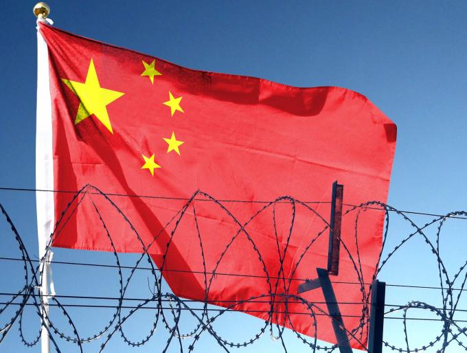 Chinese flag behind barbed wire